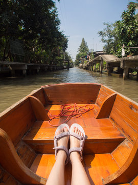 young woman wearing sandals sitting on canal boat