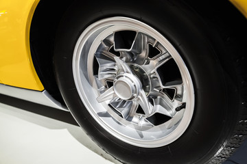 Chromed wheel disc. Yellow vintage sport car