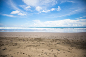 Tropical exotic beach with volcanic sand, blue sky with clouds. Nobody. Bali, Indonesia