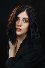 Fototapeta premium Beautiful young girl on a dark background. Studio photo of a beautiful girl