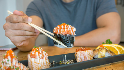 Fresh salmon eggs sushi on a black plate (Japanese food).