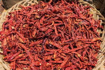 Fototapeta premium Dried Chili Peppers in basket on the wooden table background