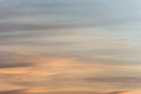 Sunset sky background with a golden orange glow on a hazy clouds