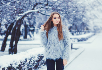 Winter portrait of young beautiful brunette woman wearing fur coat. 