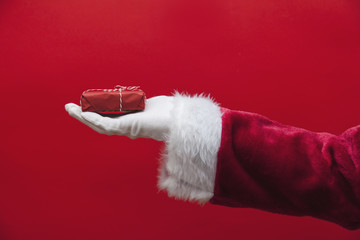 Santa Claus hand holding a Christmas present