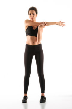 Full length image of Pleased fitness woman warming up