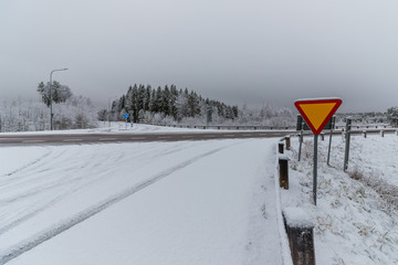a wintery cross road with a sign