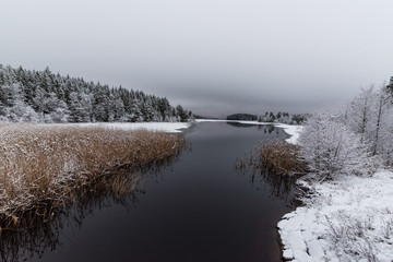 A snowy landscape overlooking water and ice