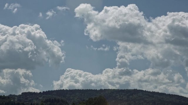 White clouds over hills timelapse.