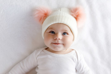 Cute adorable baby child with warm white and pink hat with cute bobbles - Powered by Adobe