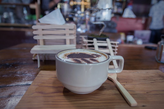 Cup of coffee on wooden dable in the coffee shop.