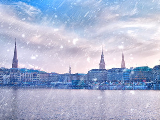Fototapeta na wymiar Winter snow town. Alster Lake and winter Hamburg cityscape
