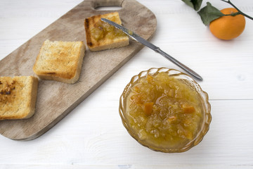 A sandwich with mandarin jam and tangerine jam is located on a light table.