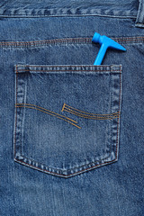 A blue toy hammer in the back pocket of a denim jean