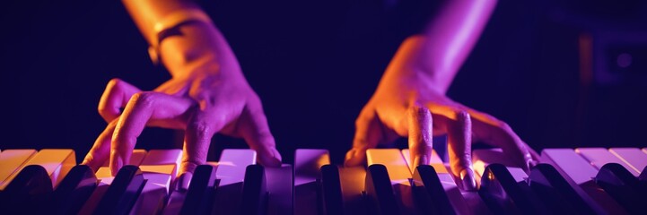 Mid section of female musician playing piano