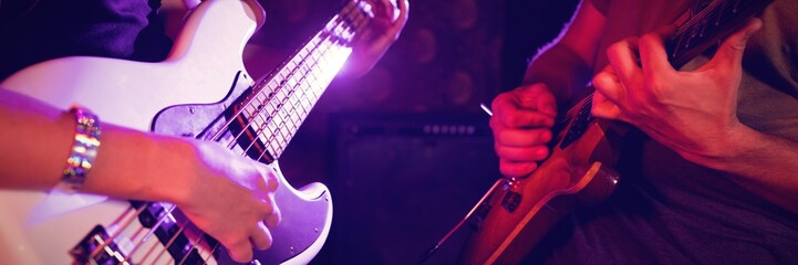 Mid section of male and female guitarist in nightclub