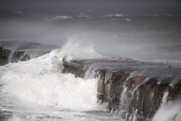 Bei Sturm brechen grosse Wellen an einer Mole in der Dänischen Nordseeeine Mole