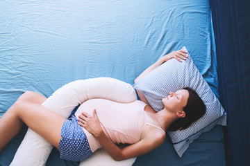 Pregnant woman relaxing or sleeping at bed.