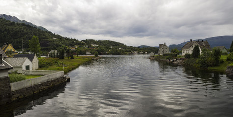 Fototapeta na wymiar Vistas desde Jondal al lago Hardangerfjorden, con agua, y perspectiva del pueblo. Vacaciones de verano en Noruega, 2017