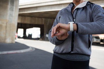 Female jogger using smartwatch on a sunny day