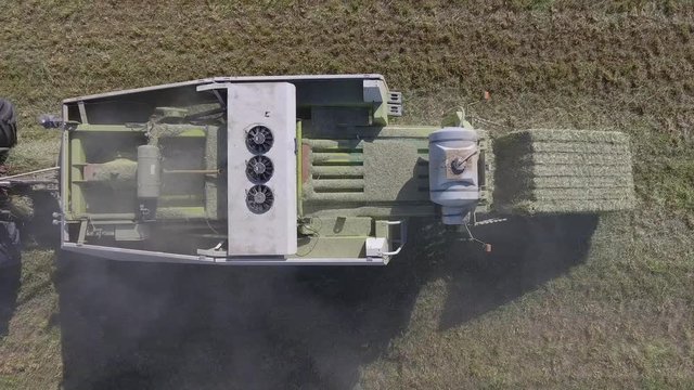 aerial hay bale production closeup above view pistons compress hay 4k