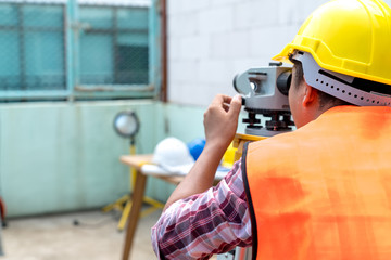 Survey engineer use theodolite elevation camera to checking construction site