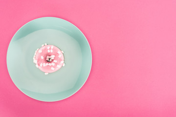 top view of glazed doughnut with marshmallow on plate isolated on pink