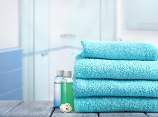 Stack of clean towels on table in bathroom