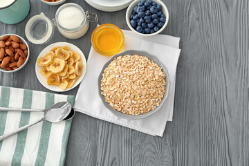 Oatmeal flakes and toppings on wooden background