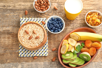 Oatmeal flakes and many different toppings on wooden background