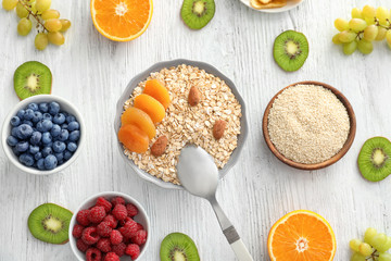 Oatmeal flakes and many different toppings on wooden background