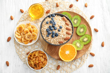 Composition with oatmeal flakes and many different toppings on wooden background