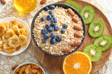 Composition with oatmeal flakes and many different toppings on wooden background