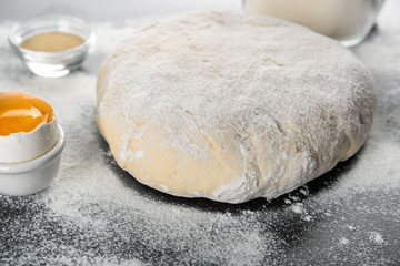Raw dough sprinkled with flour on table