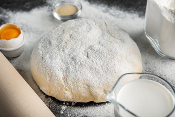 Raw dough sprinkled with flour on table