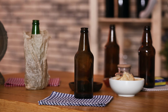 Beer bottles and snacks on table in sport bar