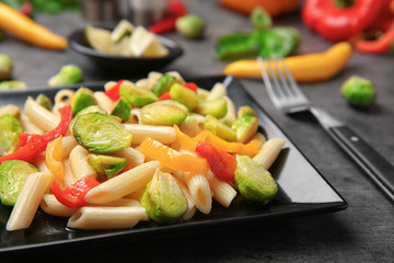 Plate of pasta with Brussels sprouts on table