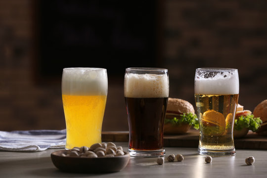 Glasses with different sorts of beer on table in sport bar