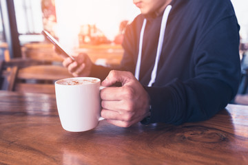 The abstract image of the business man using a smartphone in the coffee shop. the concept of online shopping, online payment, financial, freelance, technology and internet of things.