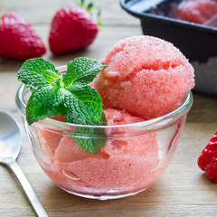 Homemade strawberry sorbet in glass on a wooden table, square