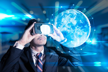 The abstract image of business man using a vr glasses overlay with earth hologram image and element of this image furnished by Nasa. the concept of communication, internet of things and future life.