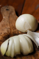 Onion cut in half on cutting board as seen from above.
