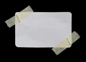 ripped note paper with adhesive tape on a black background