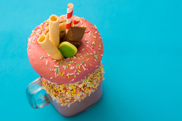 Extreme milkshake or freak shake on blue background. Copyspace