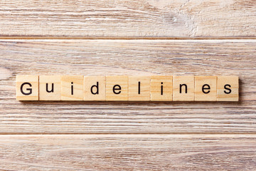 Guidelines word written on wood block. Guidelines text on table, concept