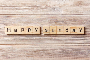 Happy sunday word written on wood block. Happy sunday text on table, concept