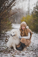 A child hugging and petting his white shaggy dog Samoyed 9855.