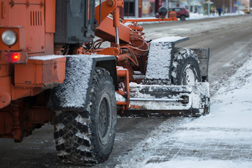 Tractor cleaning the road from the snow. Excavator cleans the streets of large amounts of snow in...
