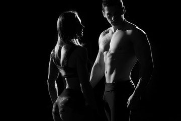 Fototapeta na wymiar Sports man and woman. Silhouettes on a black background.