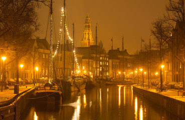 Canal with sailing ships in the Duch city of Groningen during bad winter weather.